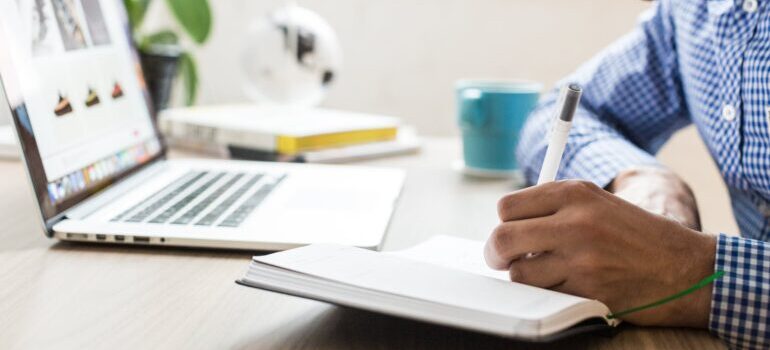 A man using a ballpoint pen on a notebook.