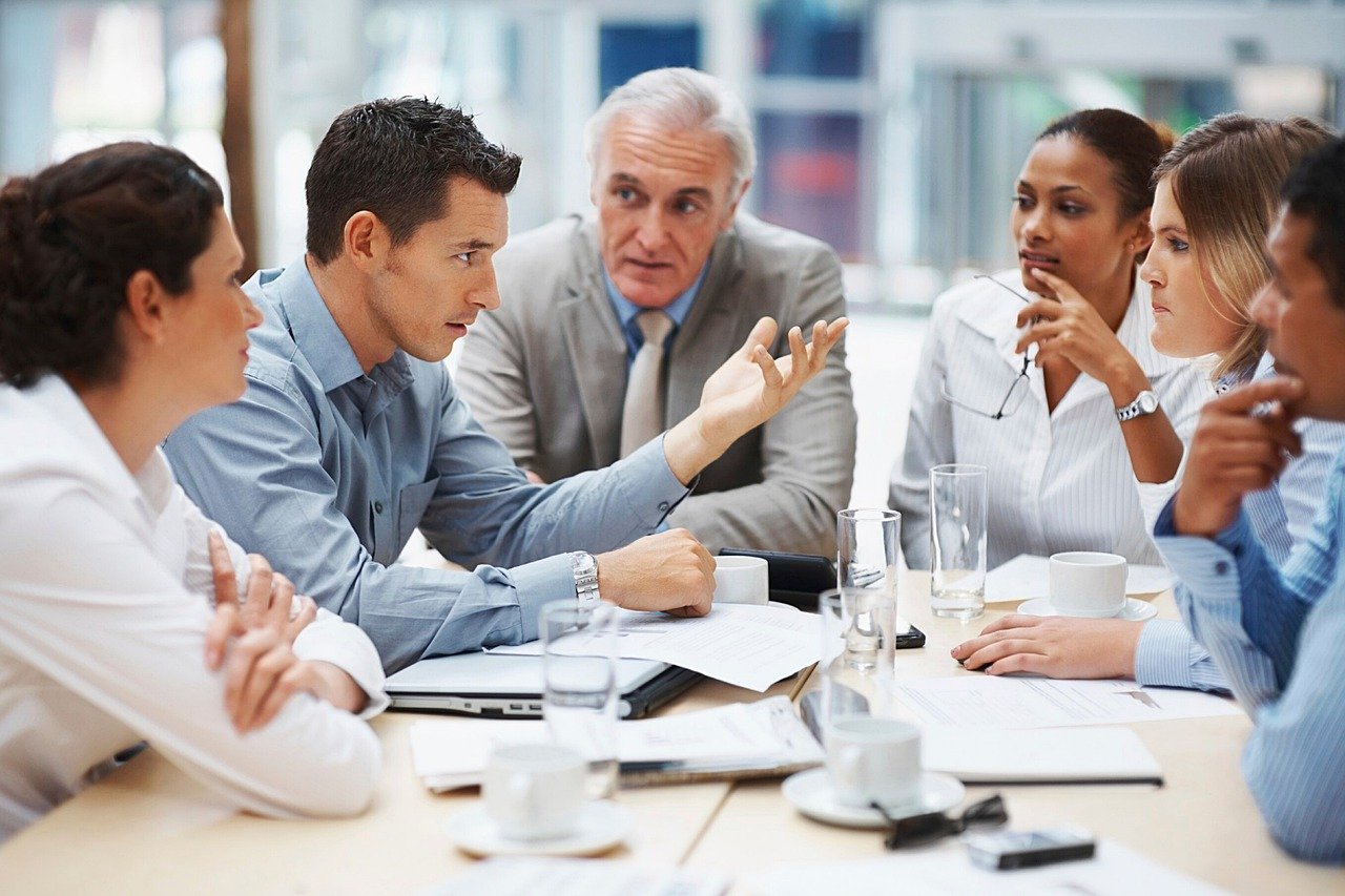 People in business attire discussing differences between small business CRM and enterprise CRM.
