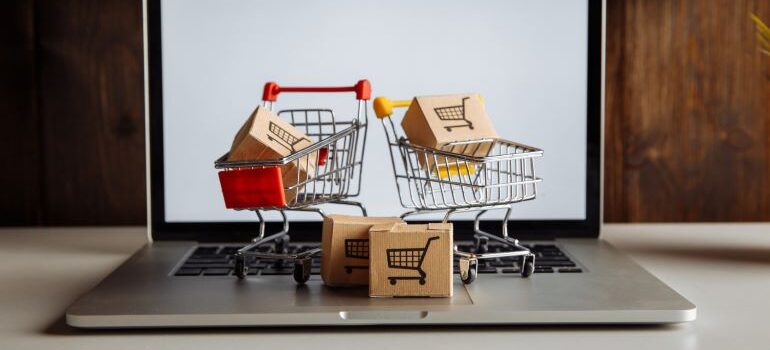 Miniature shopping carts on laptop.