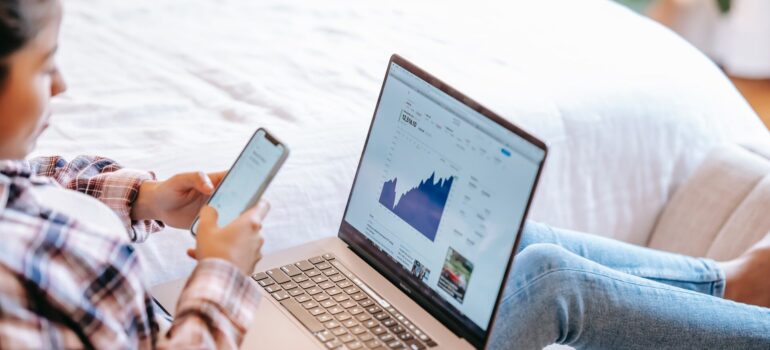 A woman working on a laptop while using historical data in forecasting.