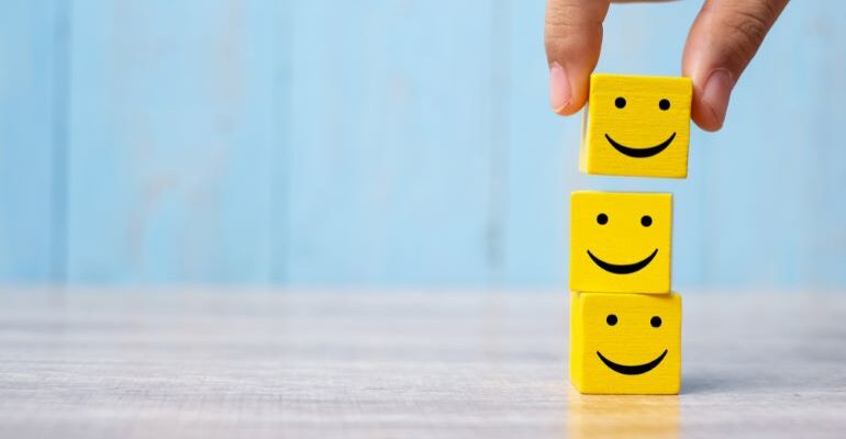 Three yellow dice with smiley faces on them.