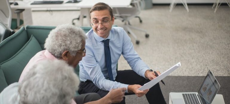 A company representative talking with an elderly couple.