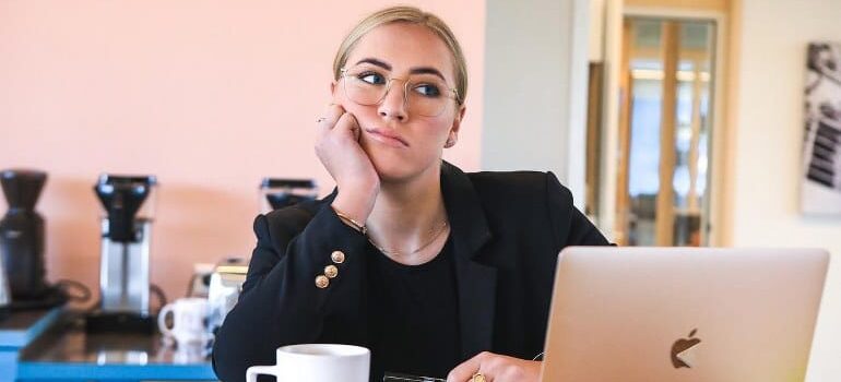 A bored woman looking at a laptop - time to redesign your website.