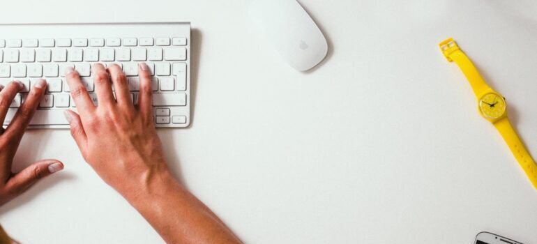 A person typing on a white keyboard.
