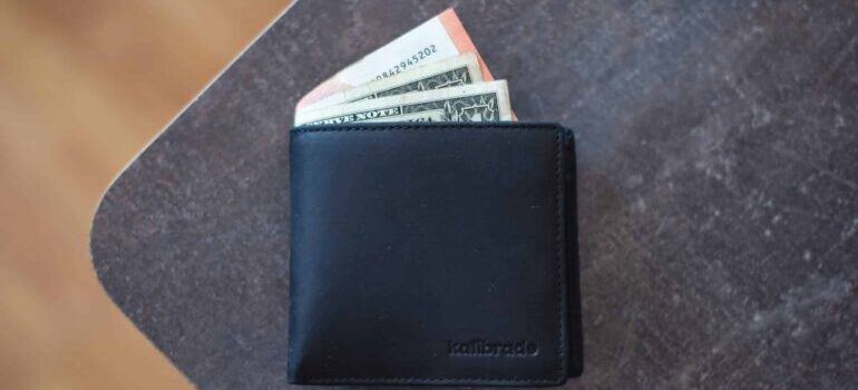 A wallet with some dollar bills inside of it.