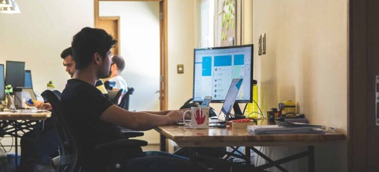 A person typing on a desktop PC.