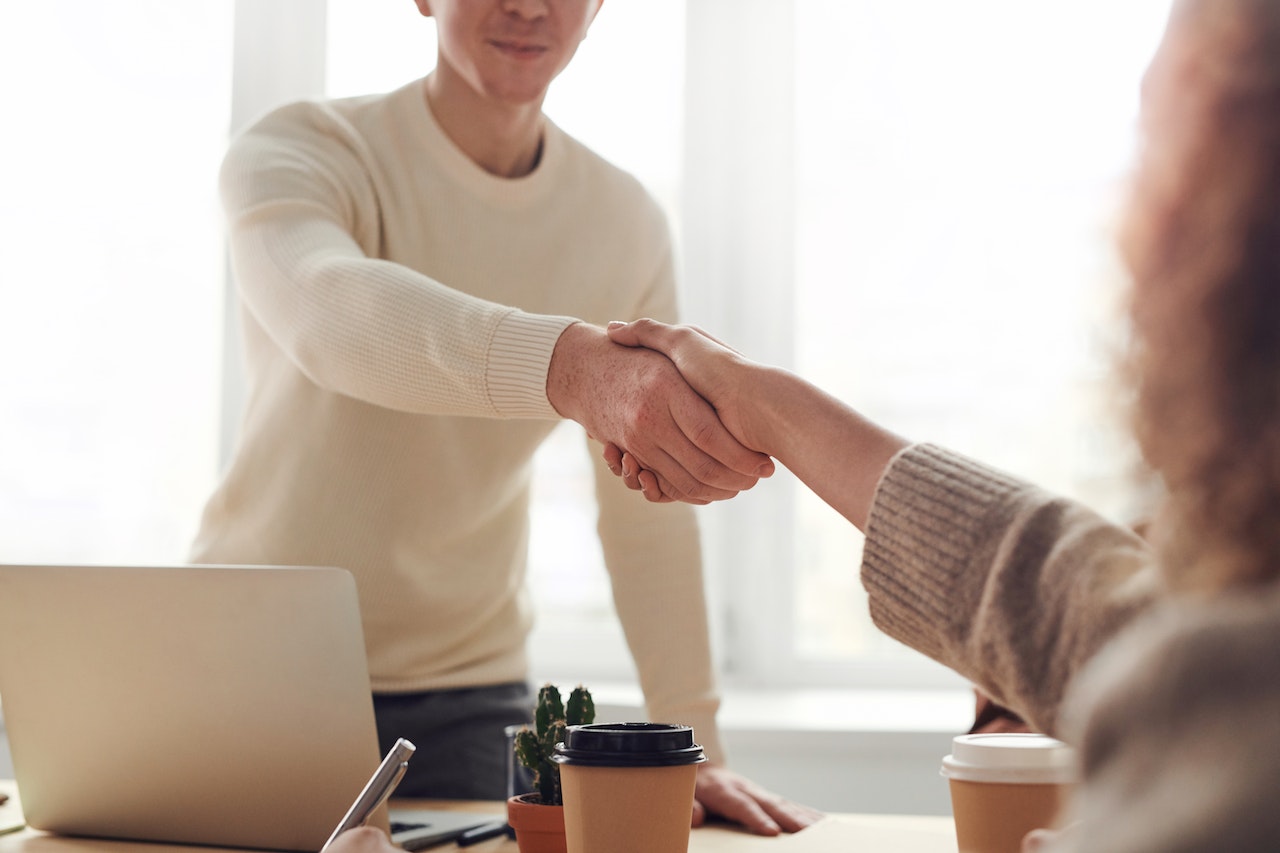 A man and a woman shaking hands after creating personalized customer experience