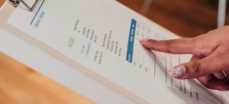 Person pointing a finger to an invoice